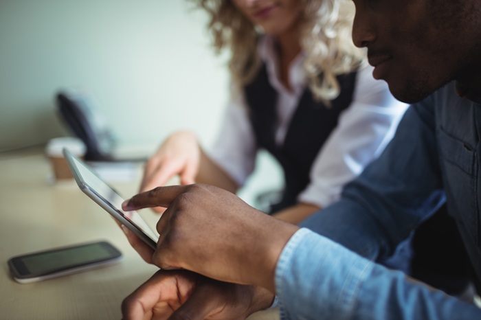 Business executives discussing over digital tablet in office