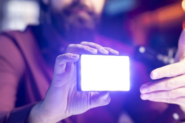 Close up shot of mini led lights, reviewed by tech guru filming technology videos. Focus on filming equipment shown by online star in blurry background to subscribers, talking in mic